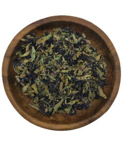 Houten kom met Butterfly Pea bloemen als natuurlijke kleurstof, perfect voor kruiden online kopen.