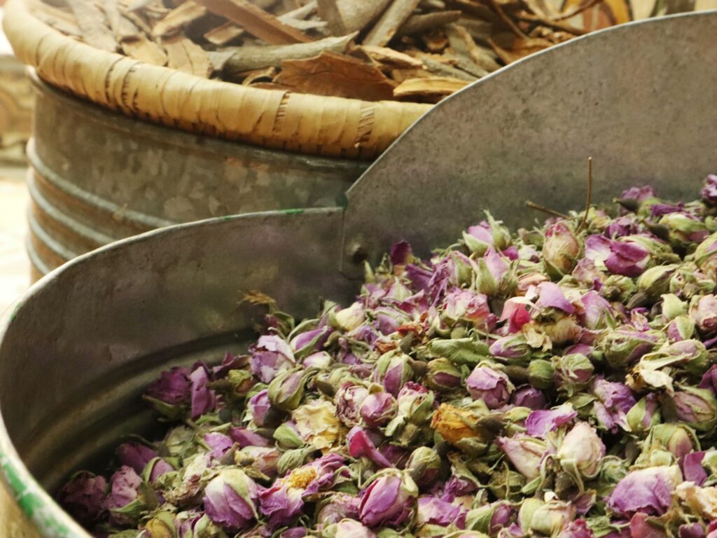 Gedroogde bloemen en kruiden in verschillende bakjes voor een eigen theemelange