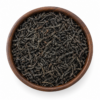 Orange Pekoe thee als droog los product in een rond houten bakje op witte achtergrond