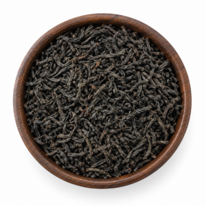Orange Pekoe thee als droog los product in een rond houten bakje op witte achtergrond
