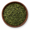 Sencha groene thee als losse droge thee in een rond houten bakje op witte achtergrond