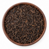 Sfeerbeeld van zwarte Ceylon thee in een rond bakje; originele productverpakking in de galerij