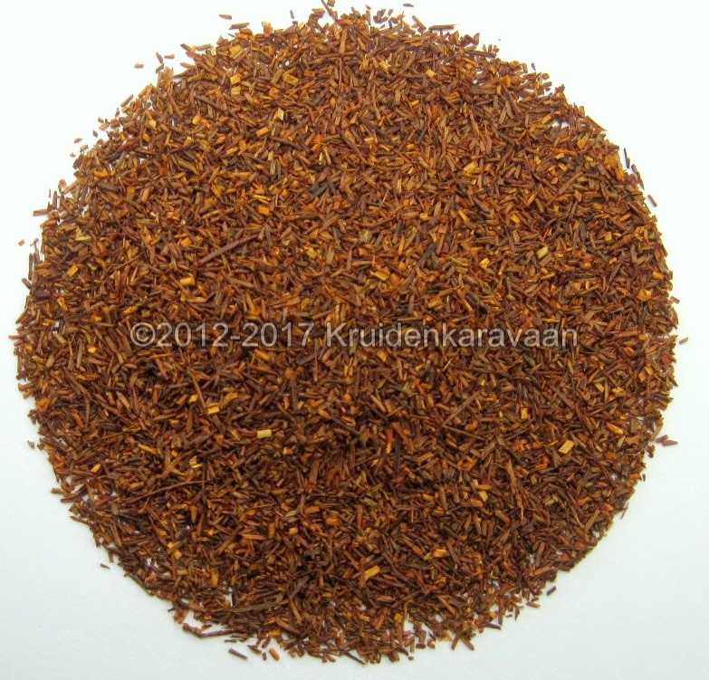 Losse Zuid-Afrikaanse rooibos thee, cafeïnevrije thee met een warme roodbruine kleur op een witte achtergrond.